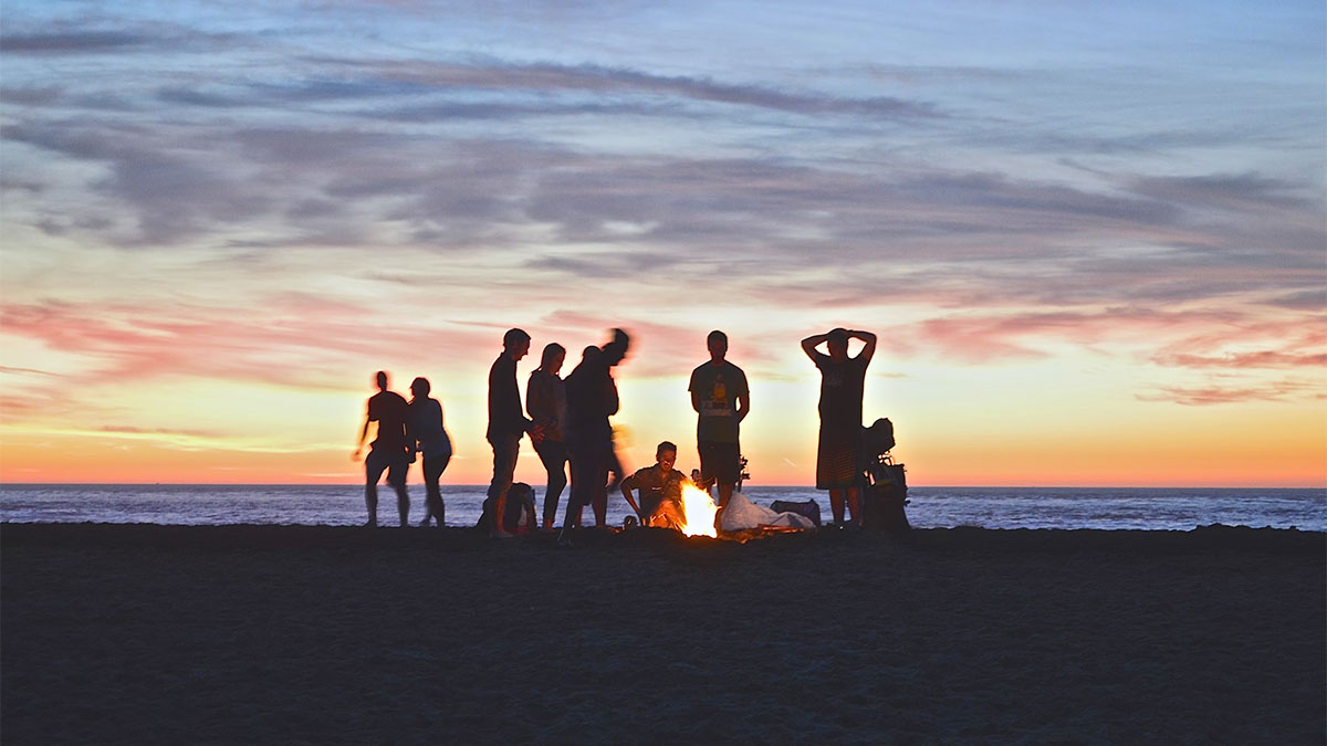 amici in spiaggia al tramonto