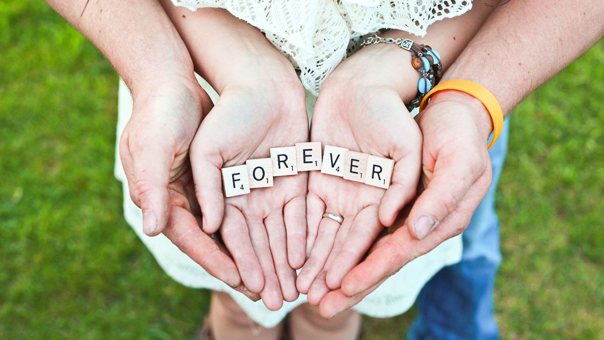 mani di una coppia con la parola forever - per sempre