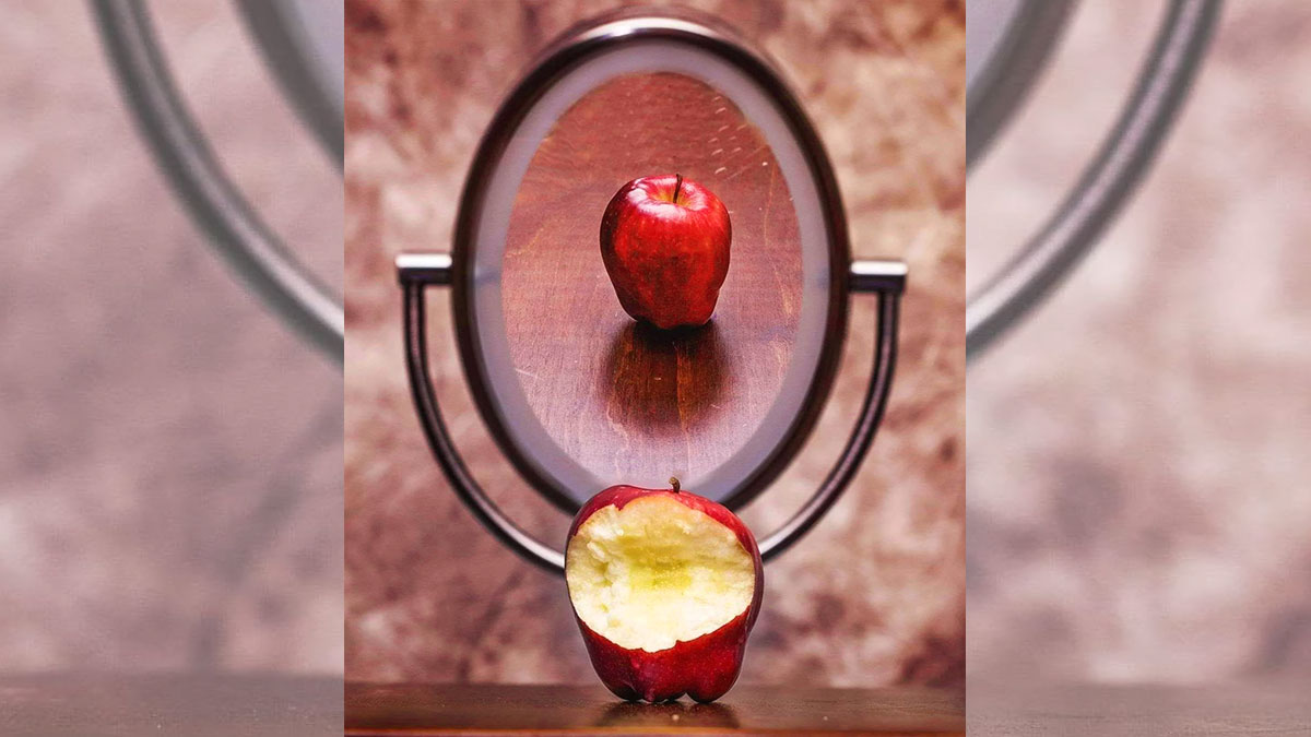 mela morsicata davanti allo specchio
