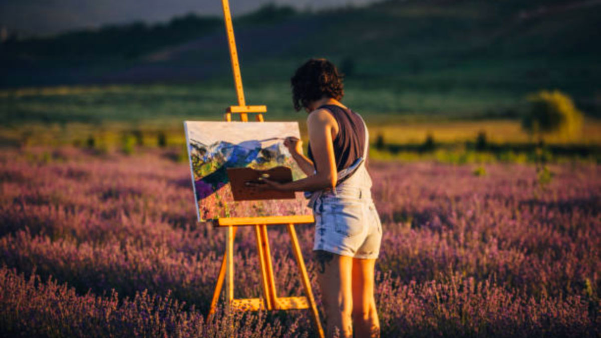 una pittrice dipinge la natura