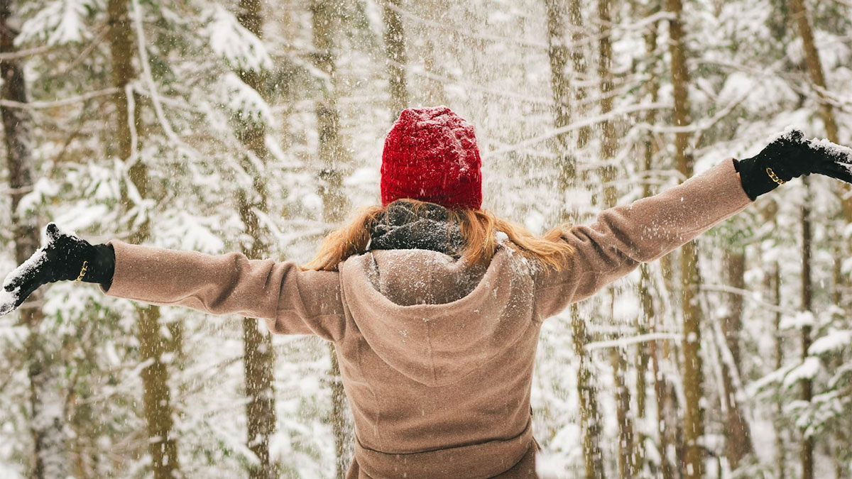 ragazza felice a braccia aperte nella neve